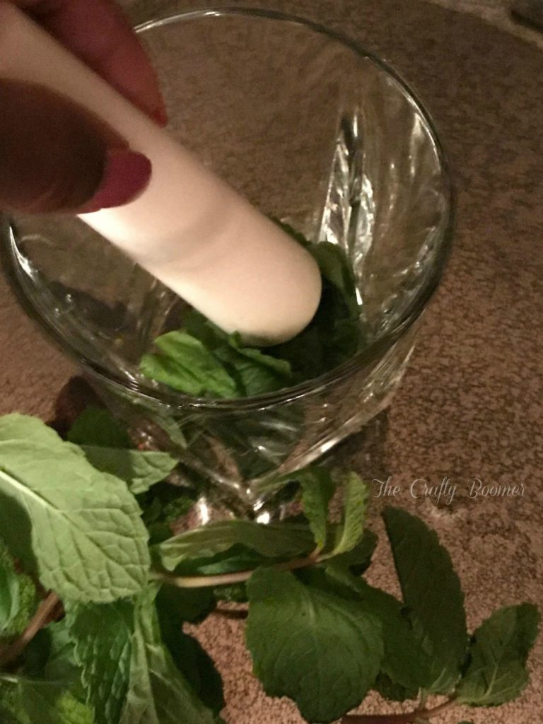 Muddle some mint in a glass to make the mint julep.